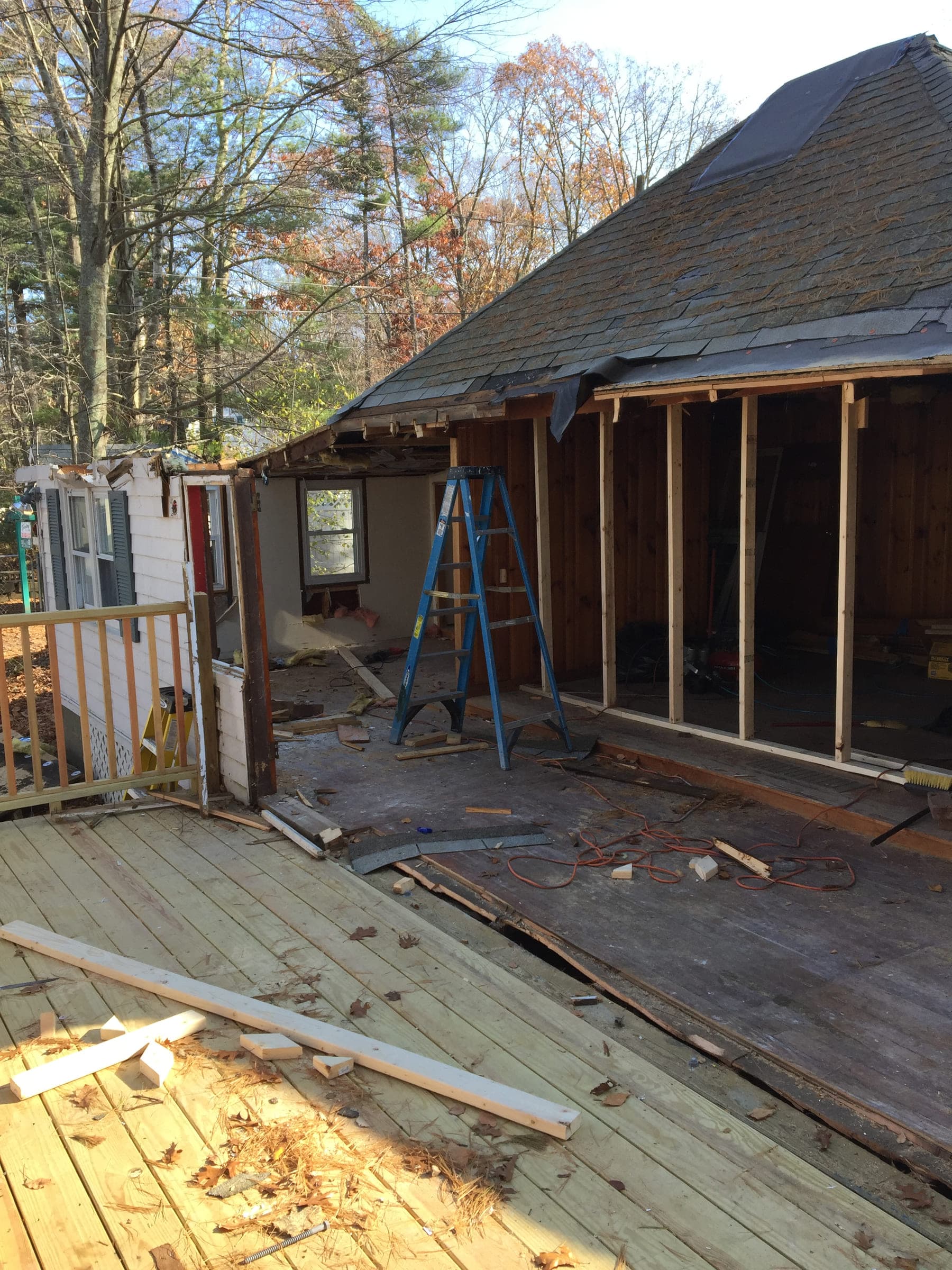 Porch rebuild in progress, with the roof structure exposed and the old deck surface lifted