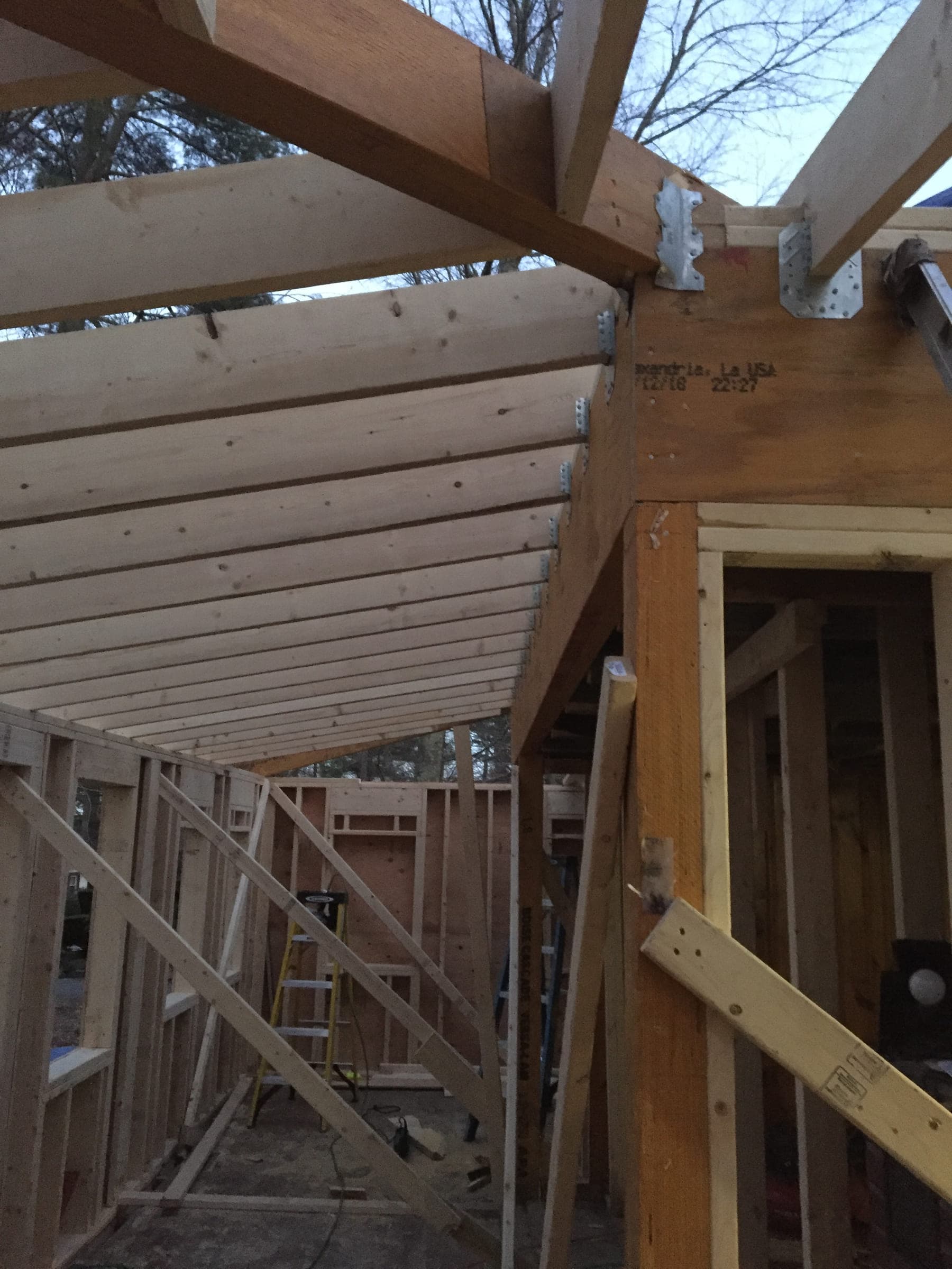 Roof framing detail showing rafters meeting a beam, fixed with galvanised structural hangers
