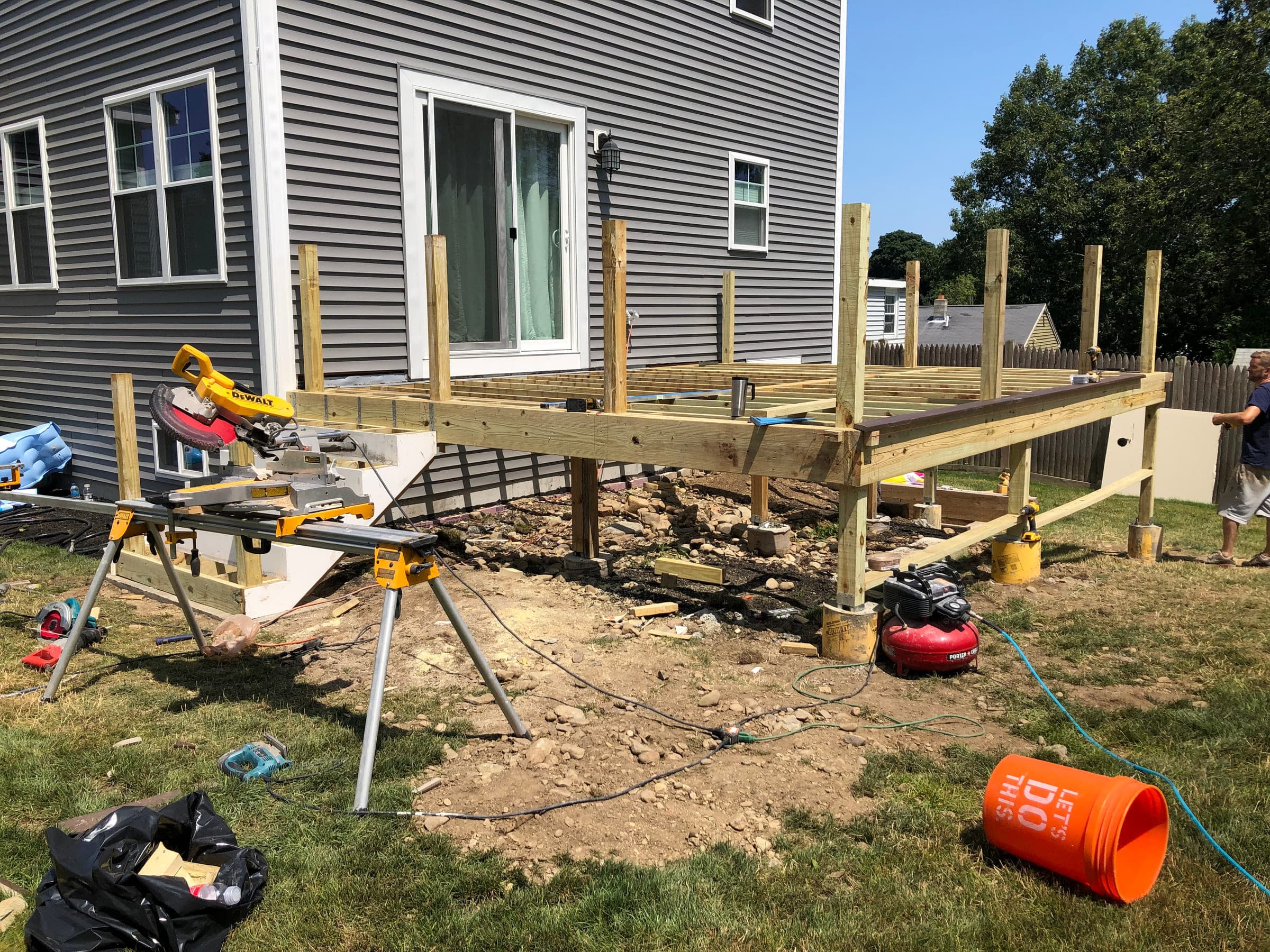 Deck under construction with timber posts set on concrete footings and the frame and joists going in