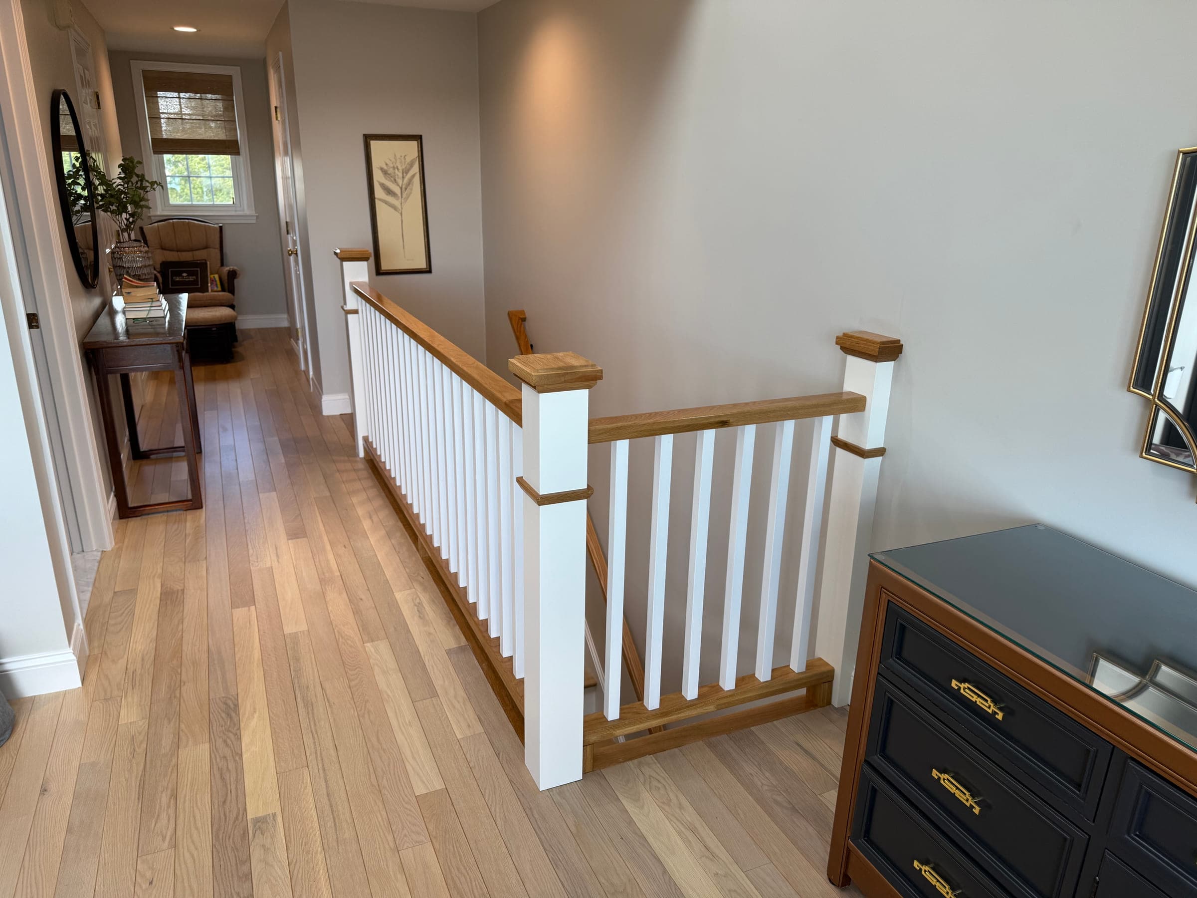 Finished landing with painted walls and white square balusters against an oak handrail and oak flooring
